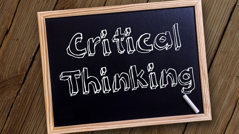 Auf einer eingerahmten kleinen Tafel steht "Critical Thinking" mit Kreide geschrieben