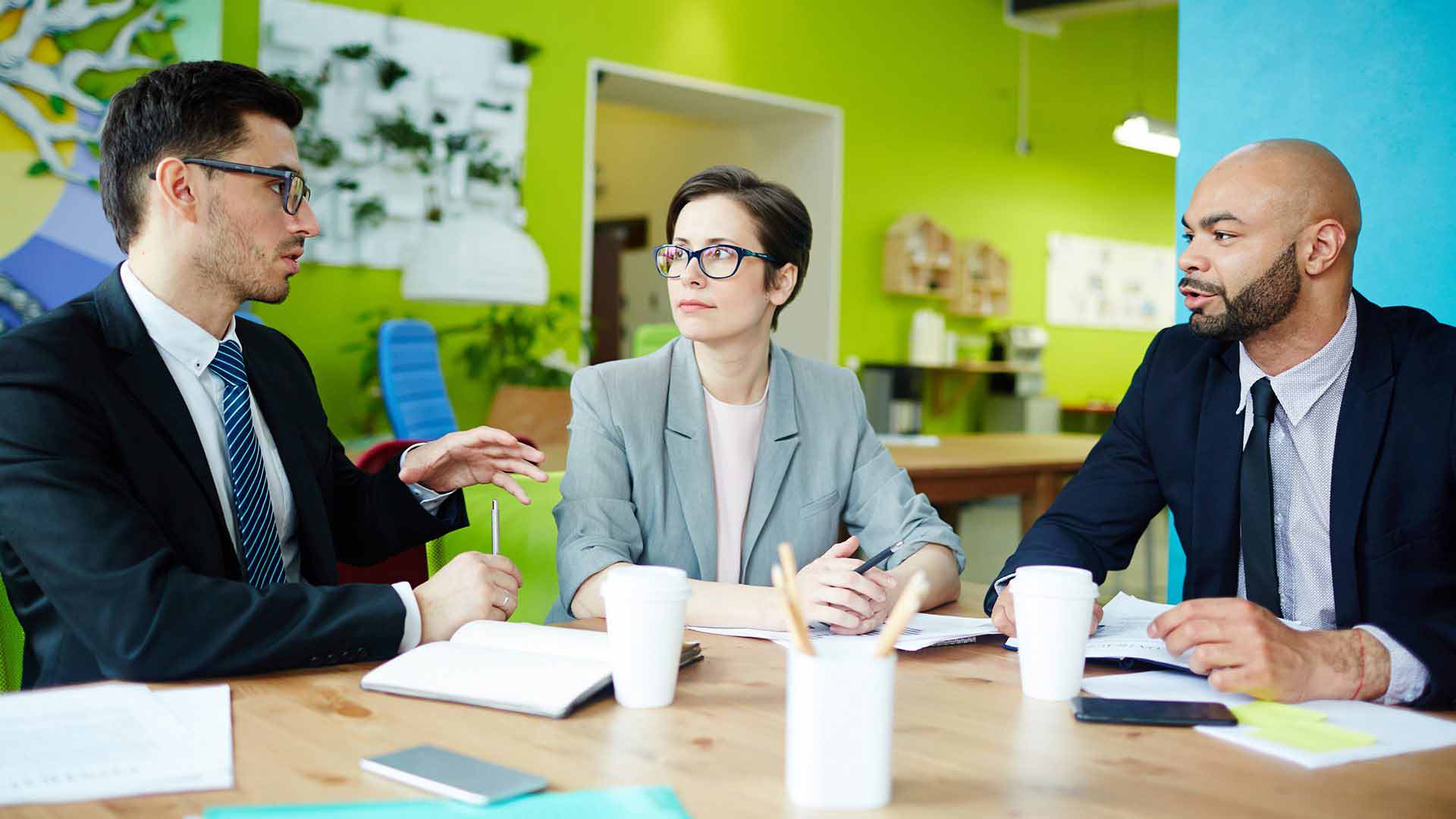 zwei Männer und eine Frau bei einer Besprechung