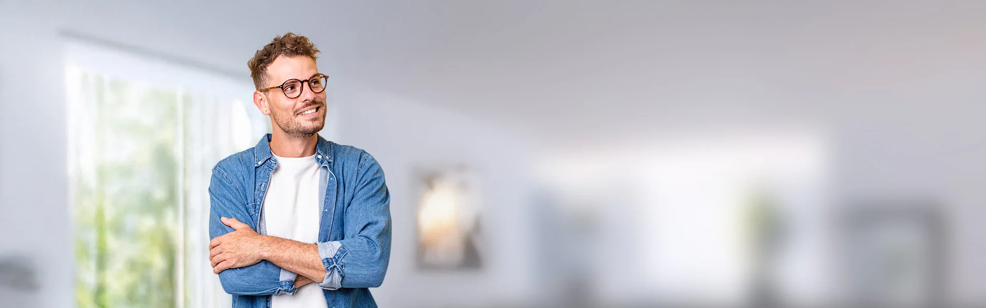 ein Mann in einem blauen Hemd mit Brille lächelt und blickt nach links