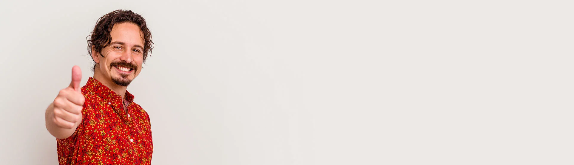 ein Mann in einem roten Hemd, der auf die Kamera zeigt