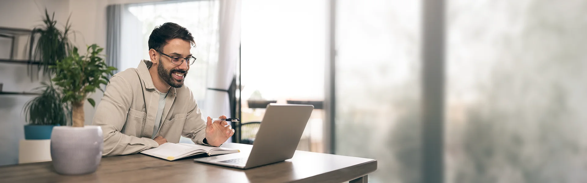 Junger Mann sitzt im Homeoffice am Laptop