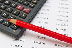 ein Bleistift und ein Taschenrechner auf einer Liste liegend