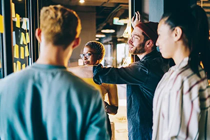 eine Gruppe von Menschen, die um einen Tisch stehen und Zusammenhalt zeigen