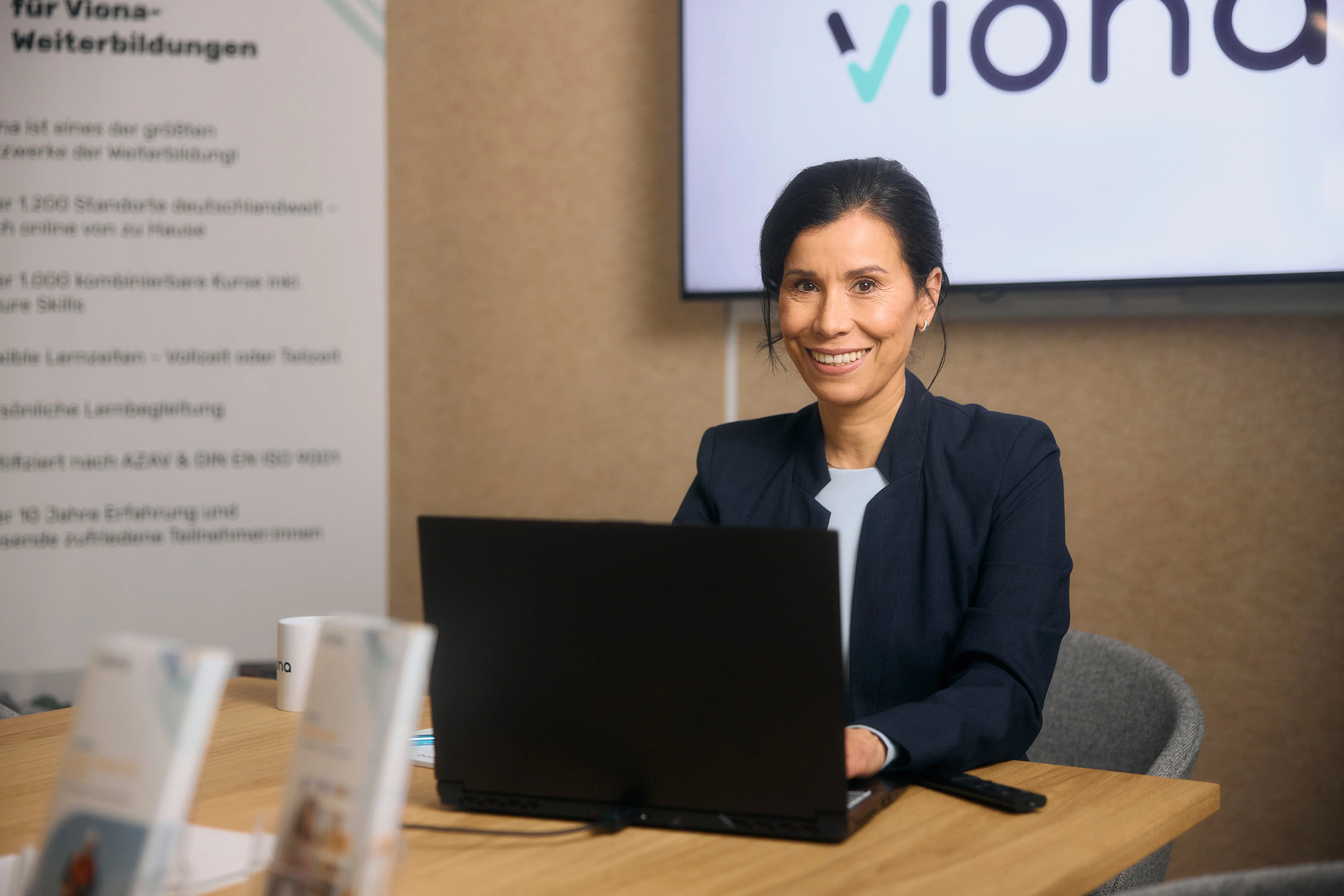Eine Viona-Beraterin sitzt vor ihrem Computer und guckt freundlich