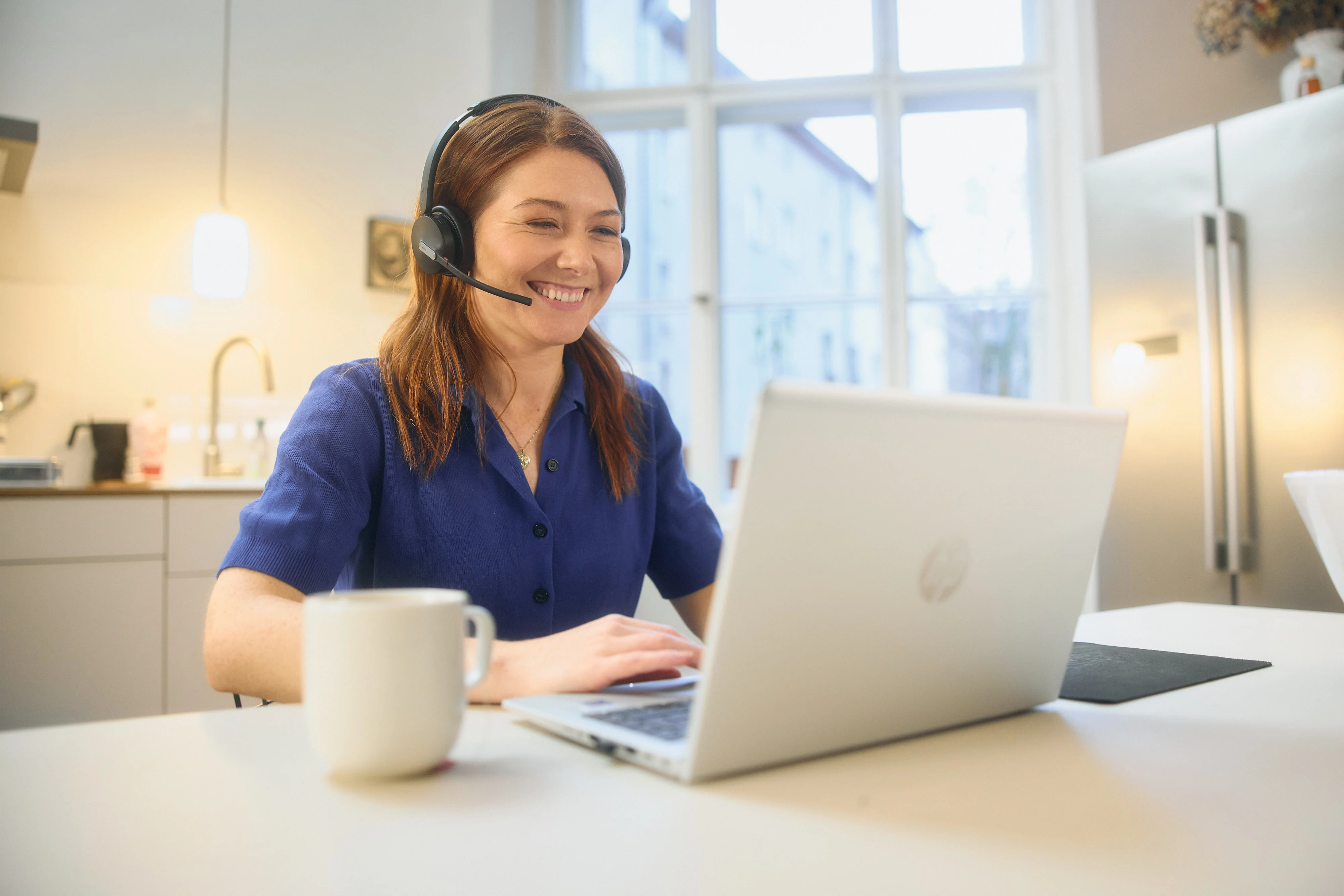 Eine Frau mit Headset sind vor einem Computer
