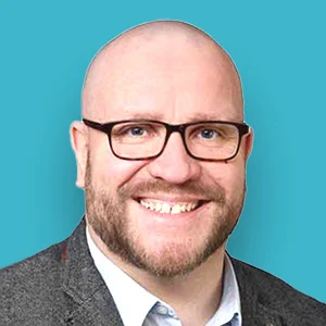 ein Mann mit Brille und einem Anzug lächelnd