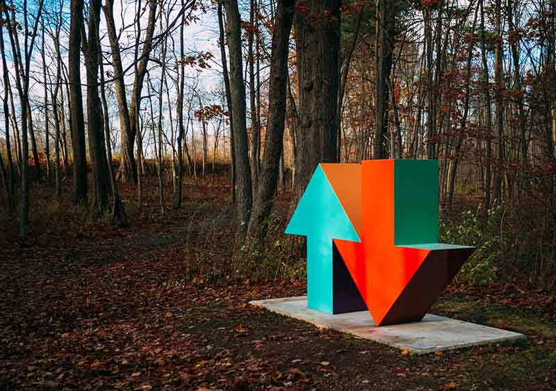 Ein grüner Pfeil und ein roter Pfeil nach unten stehen nebeneinander im Wald.