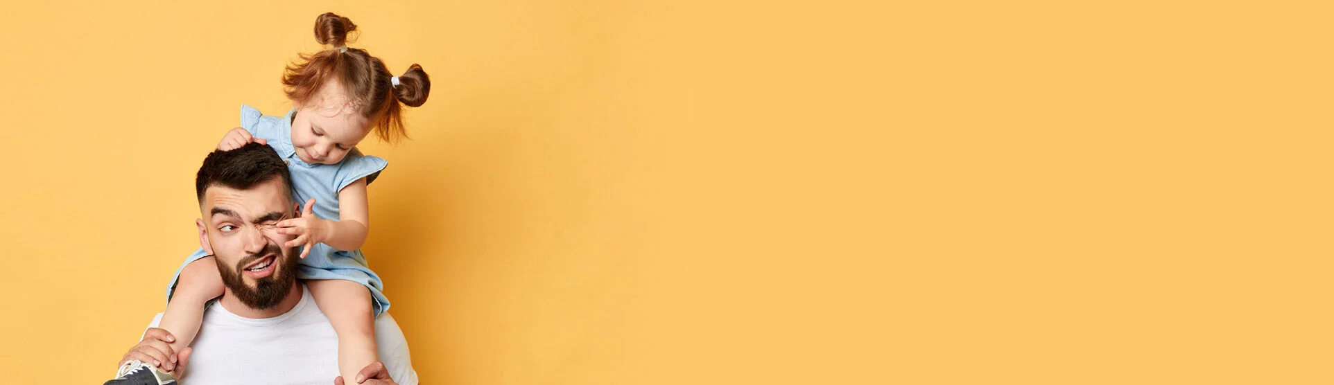 ein Mann, der ein kleines Mädchen auf seinen Schultern hält