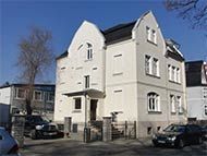 ein weißes Haus mit einem Auto vor geparkt
