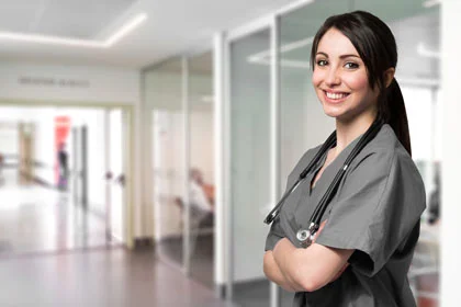 eine Frau in einer Krankenhausuniform, die im Flur steht