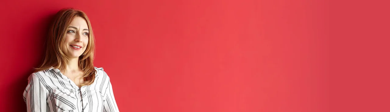 eine Frau, die gegen eine rote Wand gelehnt steht