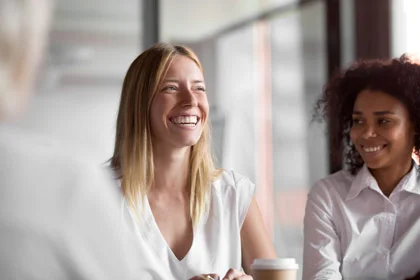drei Frauen, die an einem Tisch sitzen und reden