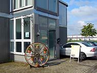 ein kleines Haus mit einem davor geparkten Auto