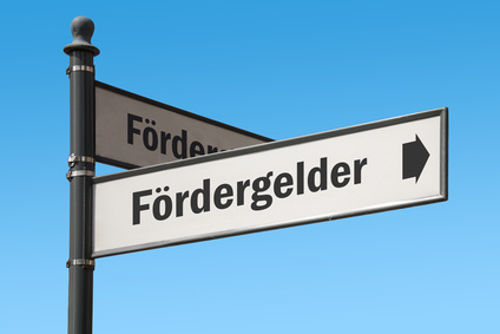 ein Straßenschild mit blauem Himmel im Hintergrund und dem Wort Fördergelder