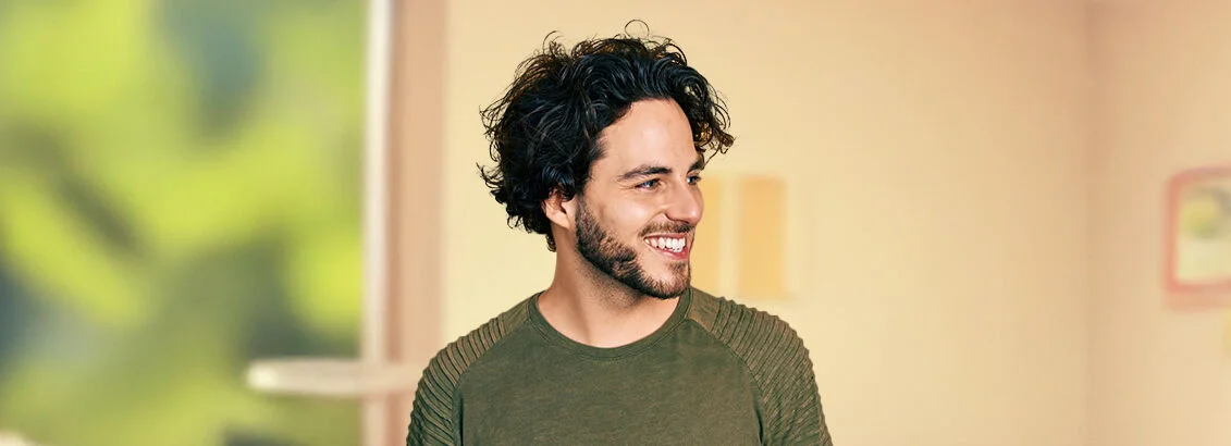 Lächelnder junger Mann mit dunklen Haaren im T-Shirt