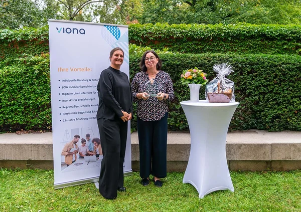 IBB-Vorstandsvorsitzende Katrin Witte (links) in einem Garten vor festlicher Kulisse bei der Preisauszeichnung des Partners ÜAG gGmbH in Jena im Jahr 2024.