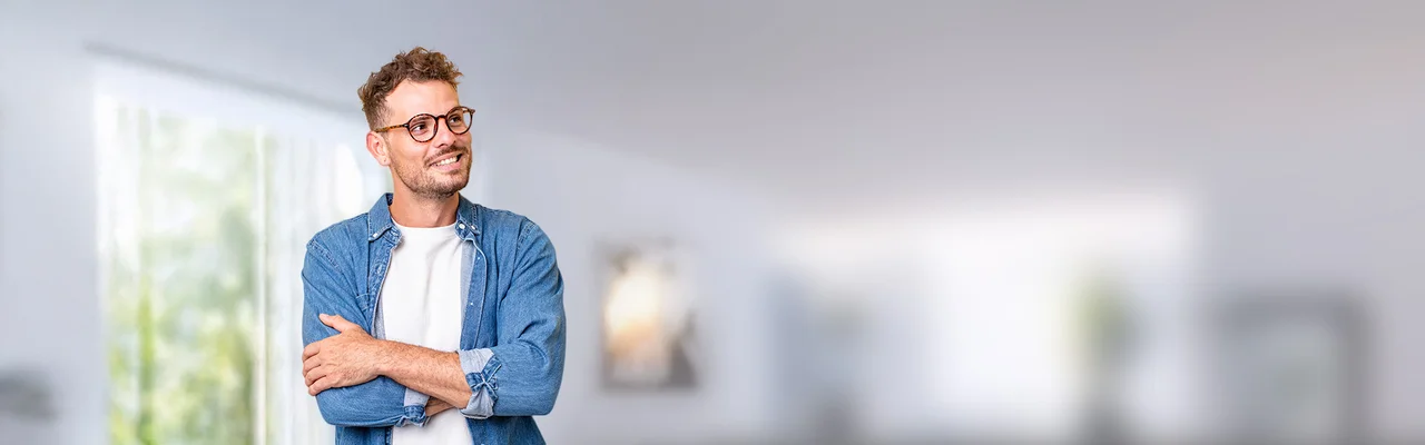 ein Mann in einem blauen Hemd mit Brille lächelt und blickt nach links