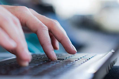 eine Person, die auf einer Laptop-Tastatur