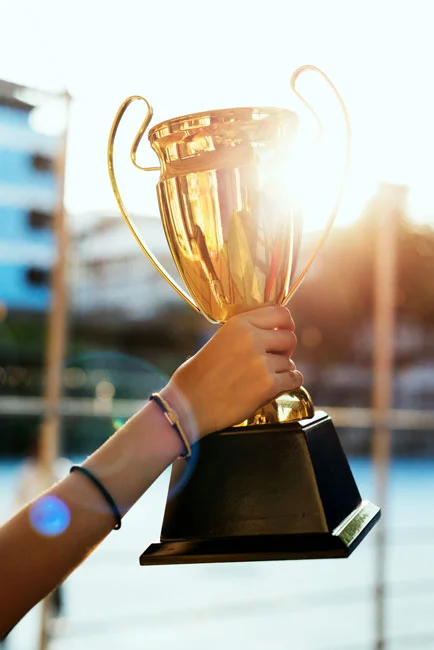 Frauenarm hält einen Pokal hoch.