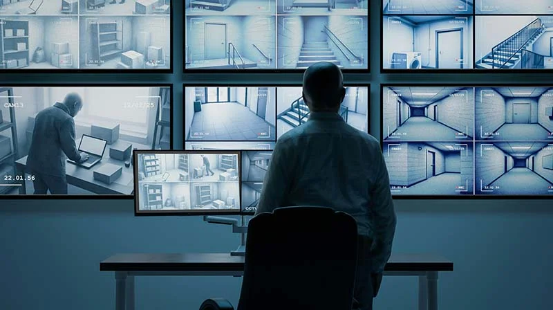 Sicherheitsbeauftragter beobachtet das Geschehen von mehreren Monitoren aus.