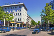 eine Straßenszene mit einer Reihe blauer Stühle