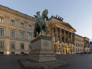 eine Statue eines Mannes auf einem Pferd vor einem Gebäude