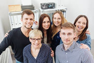sechs Menschen schauen in eine Kamera
