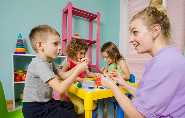 eine Frau und zwei Kinder spielen mit Spielzeug