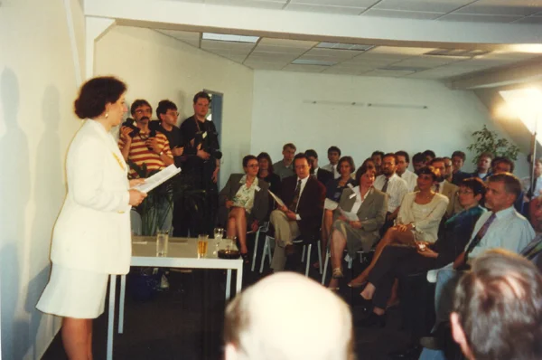 IBB-Gründerin Sigrid Baumann-Tornow vor einer Gruppe von Mitarbeitern bei der Übergabe der Zertifizierungsurkunde nach DIN ISO 9001 im Jahr 1996.