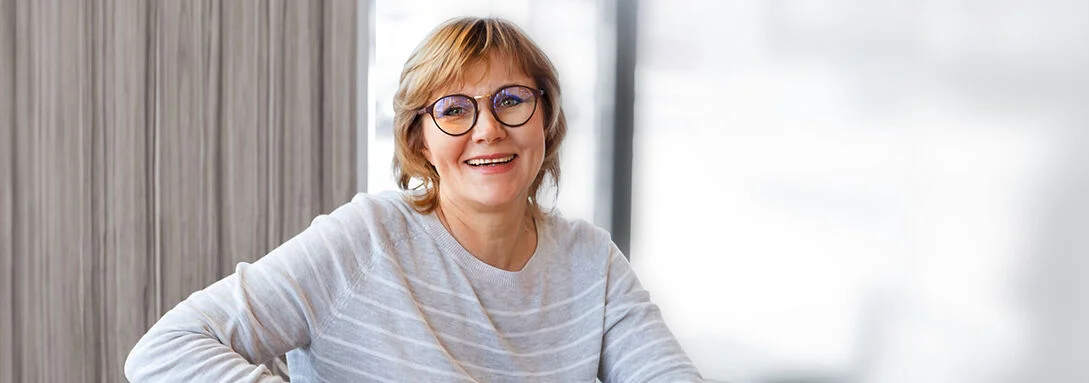eine Frau sitzt an einem Schreibtisch mit ihrem Laptop