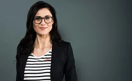 eine Frau in einem schwarzen Anzug und Brille