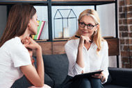 zwei Frauen sitzen auf einer Couch und unterhalten sich