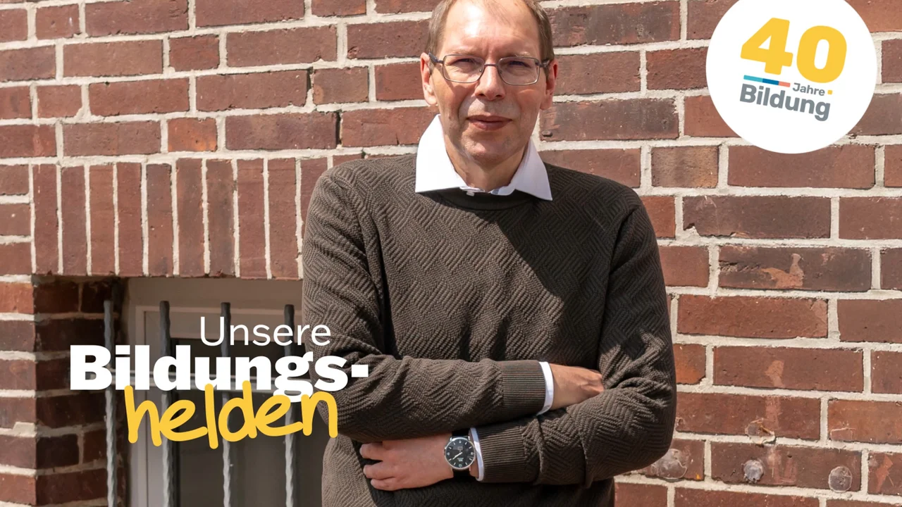 Video-Vorschaubild aus der Reihe "40 Jahre IBB - Bildungshelden": Der erfolgreiche Umschüler André Pardun steht mit verschränkten Armen vor einer geziegelten Hauswand.