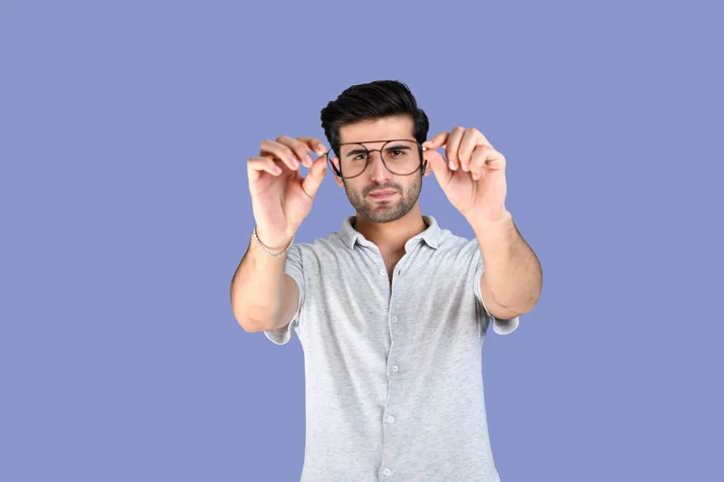 Junger Mann hält eine Brille vor die Kamera; Symbolbild für Beratungs- und Weiterbildungsangebote im Rahmen des Bildungsgutscheins 2026