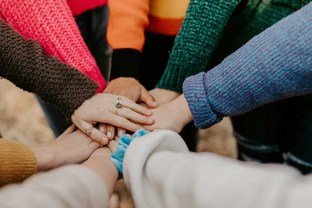 eine Gruppe von Menschen, die Hände halten