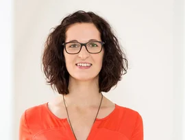eine Frau mit Brille und einem roten Oberteil