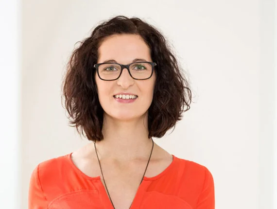eine Frau mit Brille und einem roten Oberteil