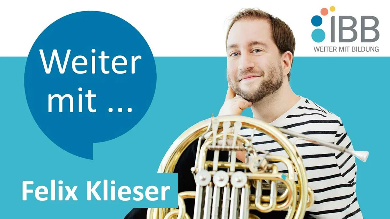 ein Mann in gestreiftem Hemd mit einem französischen Horn