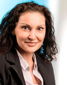eine Frau in einer schwarzen Jacke und schwarzen lockigen Haaren